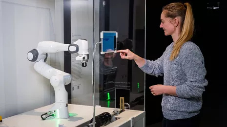 Robin Kirschner testet den taktilen Roboter. Foto: Astrid Eckert / TUM